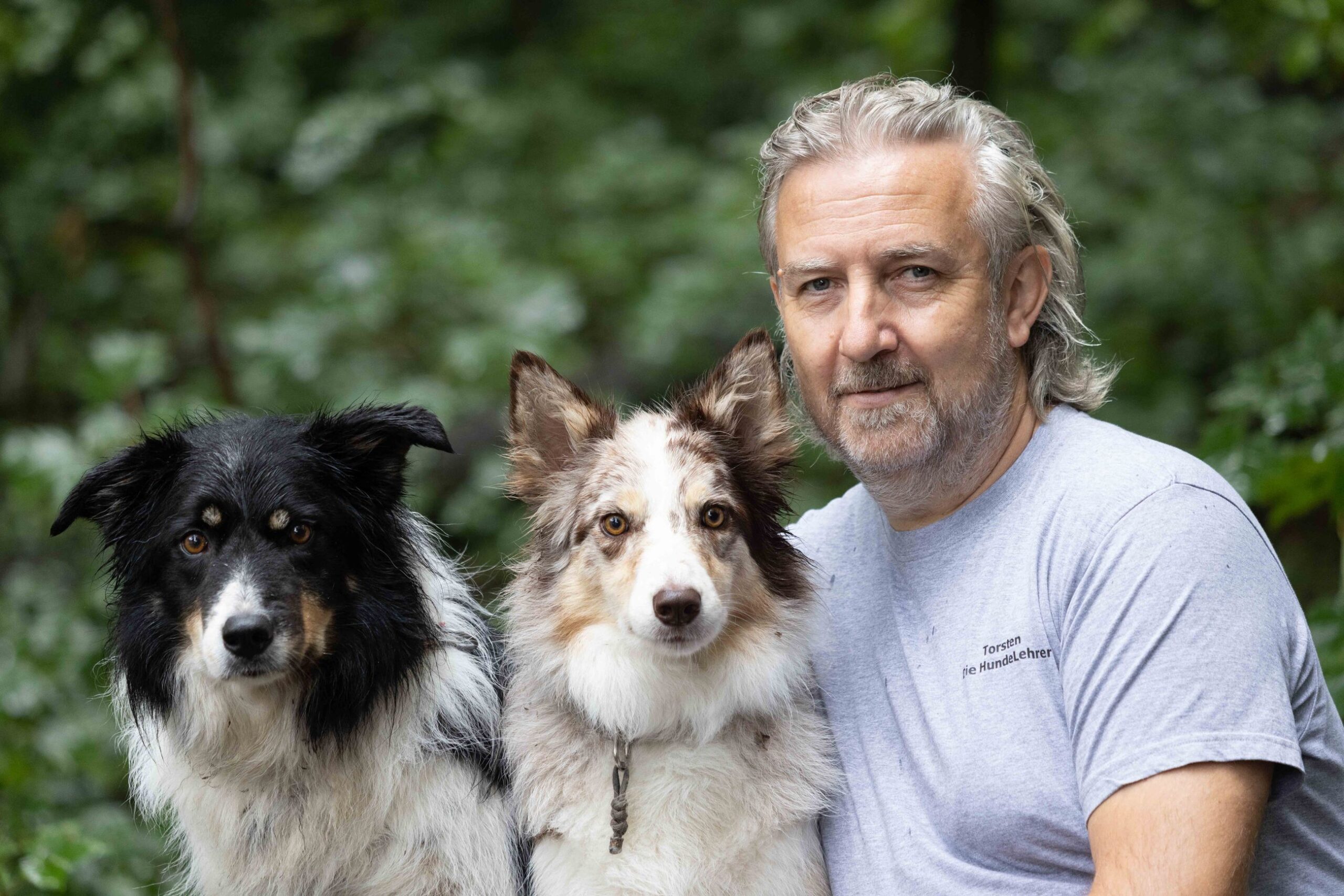 Hundelehrer Torsten Kurz mit seinen Border Collies Cathy und Dörte im Grünen